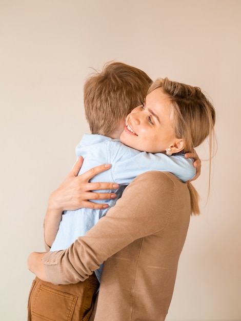 Free photo adorable young boy hugging his mother