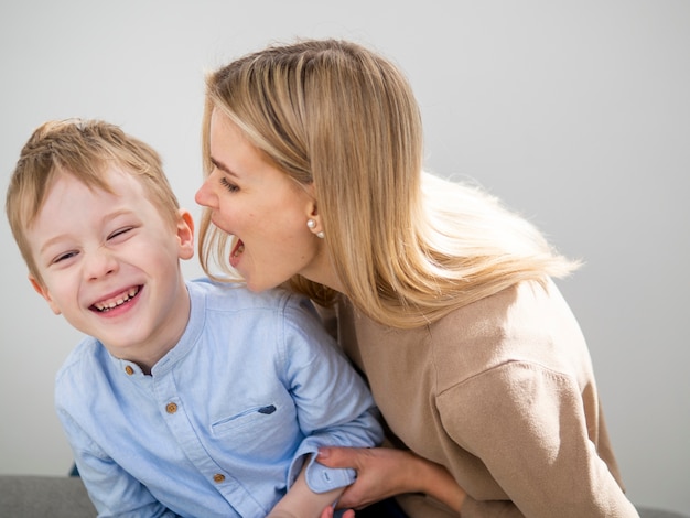 Adorable young boy and mother playing together