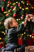 Free photo adorable young boy playing with christmas toys