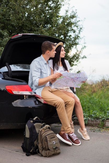 Adorable young couple taking a break on the road