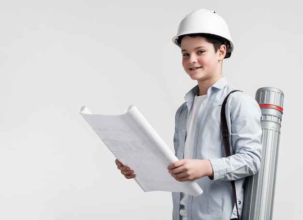 Free photo adorable young engineer holding construction plan