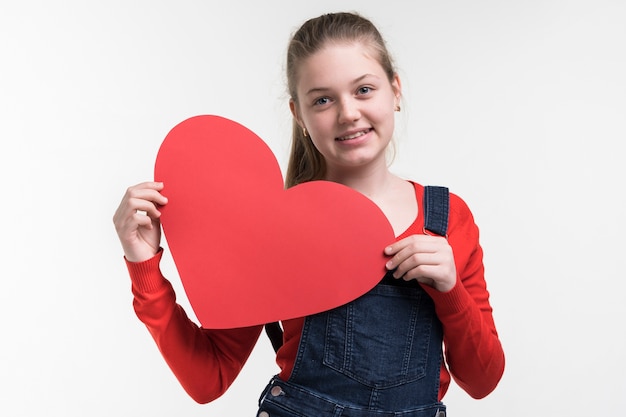 Free photo adorable young girl holding a heart