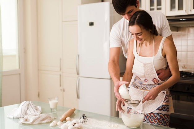 Adorable young man and woman cooking together