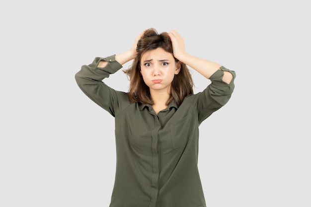 Adorable young woman in casual outfit standing and thinking