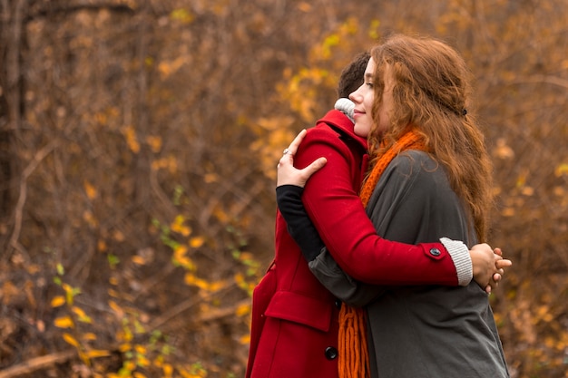 Adorable young women hugging each other