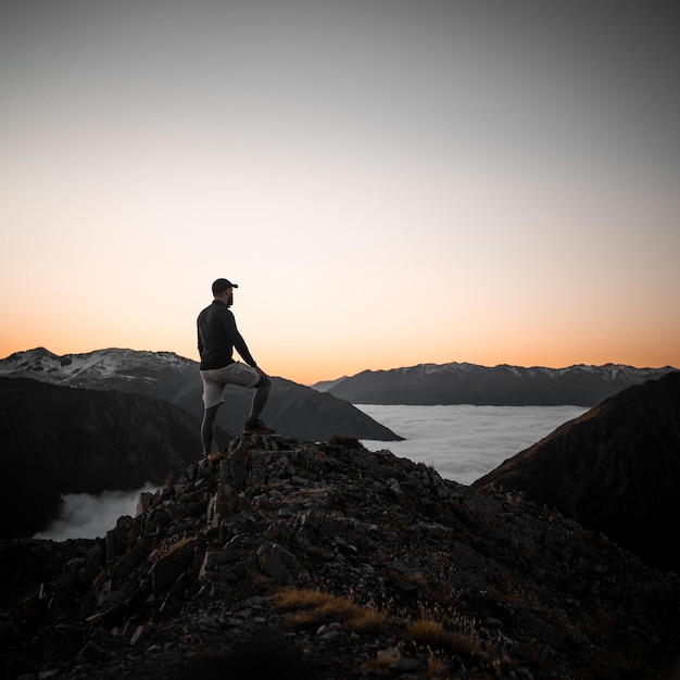 Free Photo adult caucasian male hiker standing on a hill during the sunset in lithuania