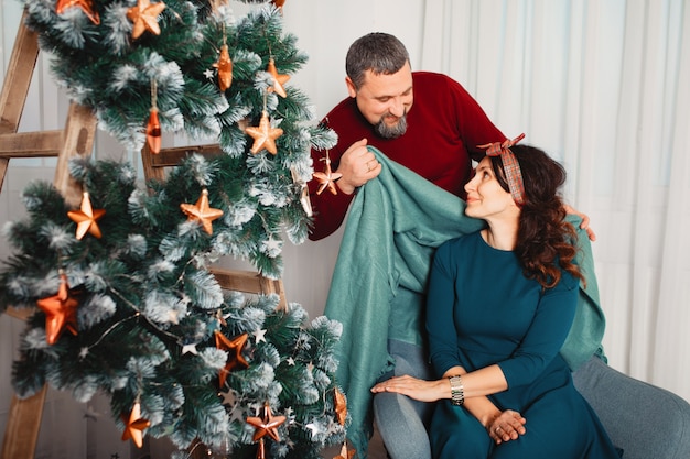 Adult family sitting at home near christmas tree