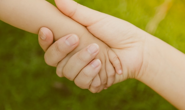 Adult hand grabbing a baby hand