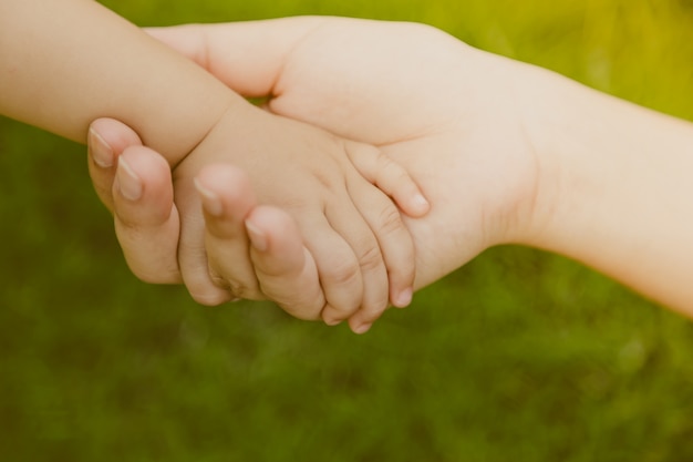 Adult hand grabbing a baby hand