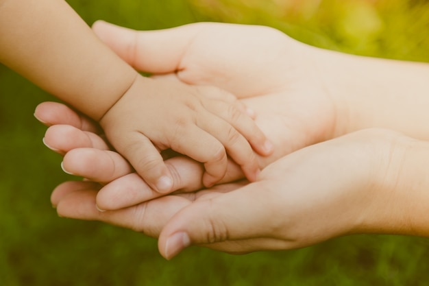 Adult hand grabbing a baby hand