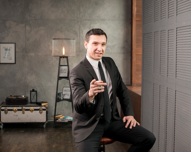 Adult happy businessman pointing at camera