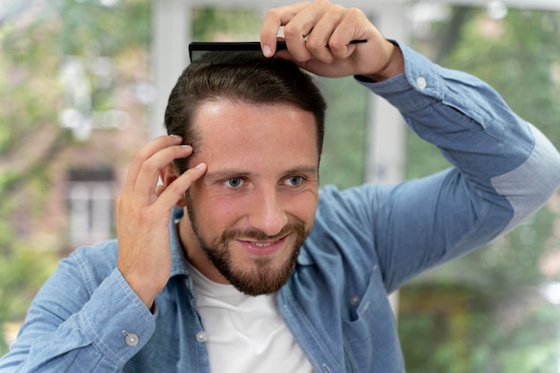 Adult male brushing his hair