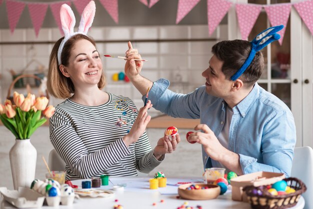 Adult male painting mothers face for easter