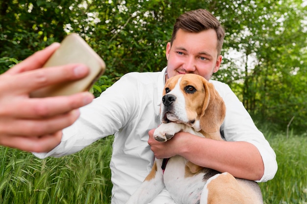 Free photo adult male taking a selfie with dog