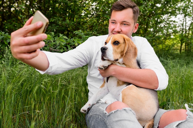 Free photo adult male taking a selfie with his dog