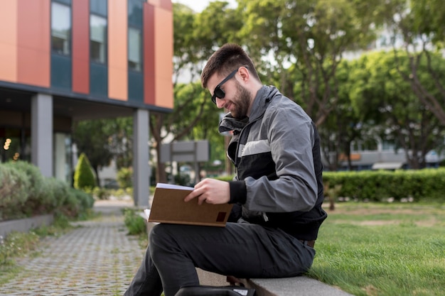 Adult man sitting on bench and learning