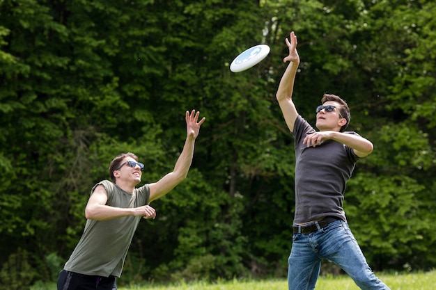 Free photo adult men jumping high for catching frisbee