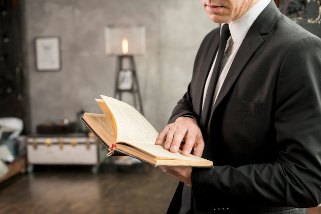 Adult stylish businessman reading book