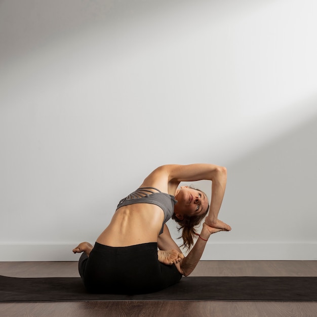 Free photo adult woman practicing yoga at home