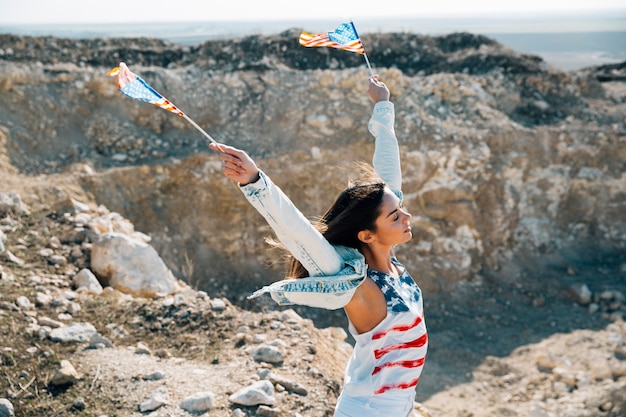 Adult woman raising hands with American flags