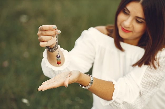 Free Photo adult woman showing meditation tool on meadow