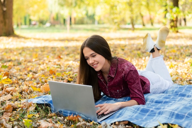 Adult woman working on laptop outdoors