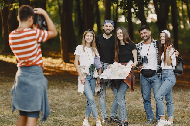 Free Photo adventure, hike and people concept. group of smiling friends in a forest. guy take a photo.