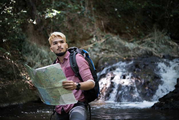 Free Photo adventure man observing map on a mountain path  to find the the right way.