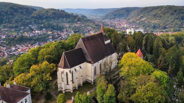 Free photo aerial drone view of the historic centre of sighisoara romania church on the hill surrounded