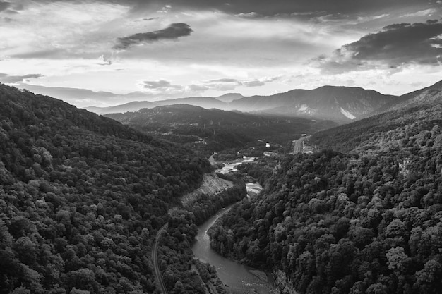 Free photo aerial greyscale shot a mesmerizing mountainous scenery under the cloudy sky