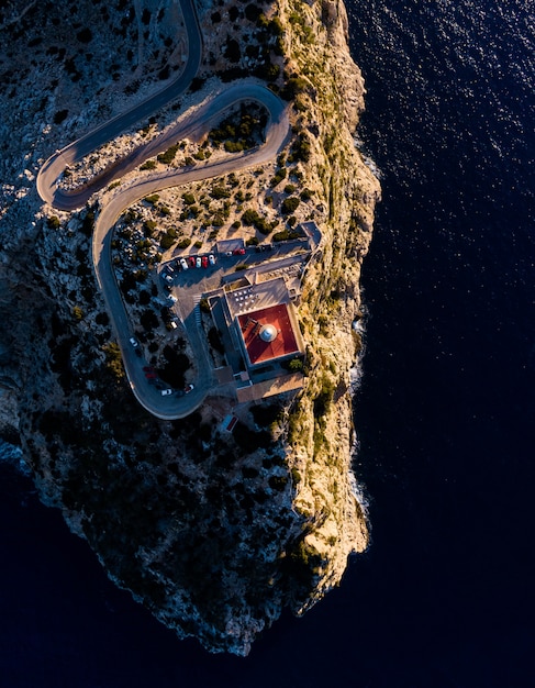 Free Photo aerial overhead shot of cliffs with a tower on top in the middle of the ocean