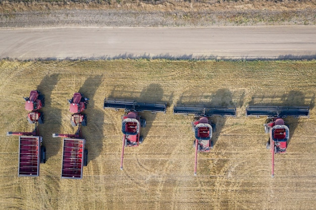 Aerial overhead shot of combine harvesters in a farming field during daytime