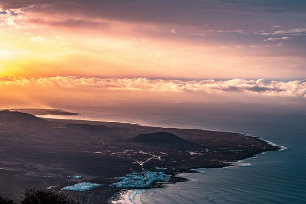 Aerial shot of a beautiful coastal city seashore with amazing clouds and sunlight on the left