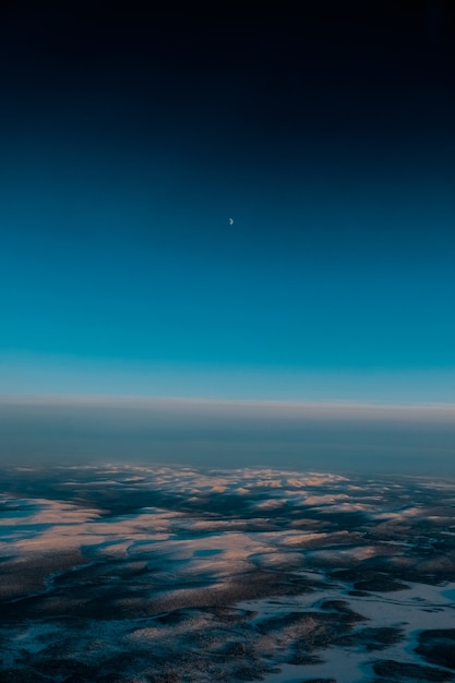 Aerial shot of a beautiful landscape covered with snow in the early morning