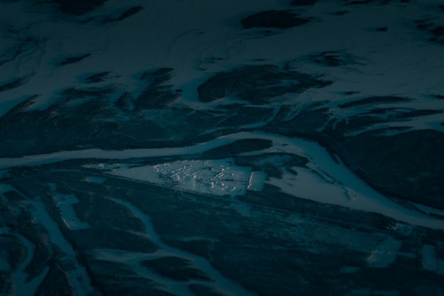 Aerial shot of a beautiful landscape covered with snow in the early morning