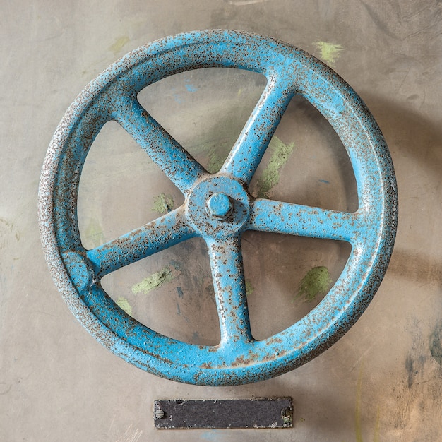 Free Photo aerial shot of a blue antique wheel on a concrete floor in daytime