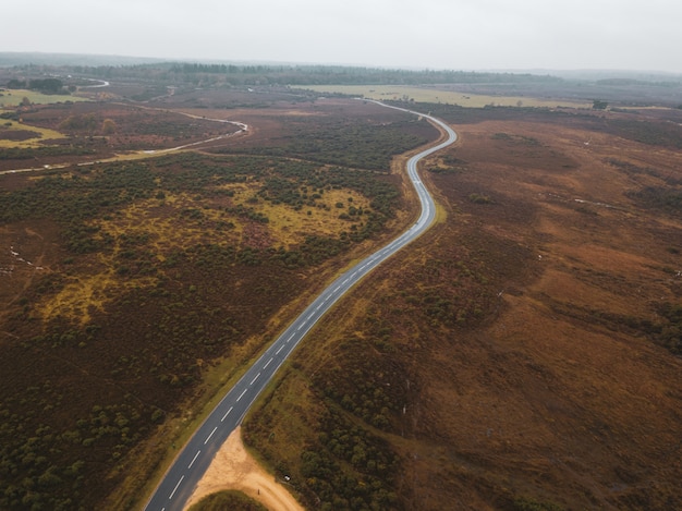 Free photo aerial shot of a road in the middle of a green landscape in the new forest, near brockenhurst, uk