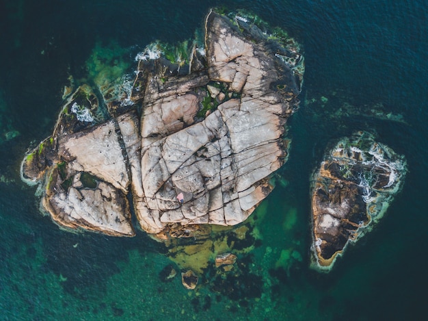 Free photo aerial shot of a rocky island in an ocean