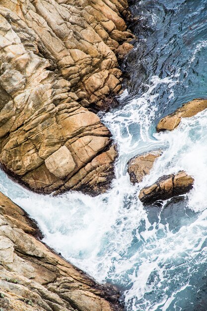 Aerial shot of sea waves hitting the rocks