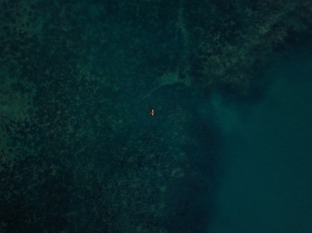 Free Photo aerial shot of the sea with a small kayak visible in the distance