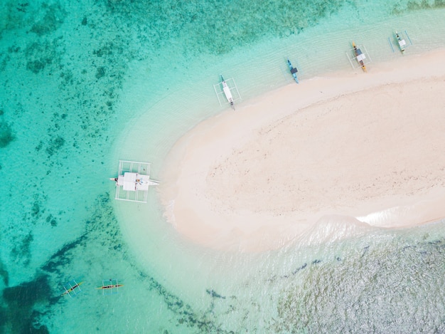 Free Photo aerial shot of a small sandy island surrounded by water with a few boats