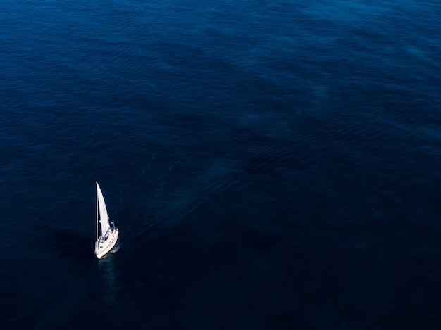 Free Photo aerial shot of a small white boat sailing in the ocean