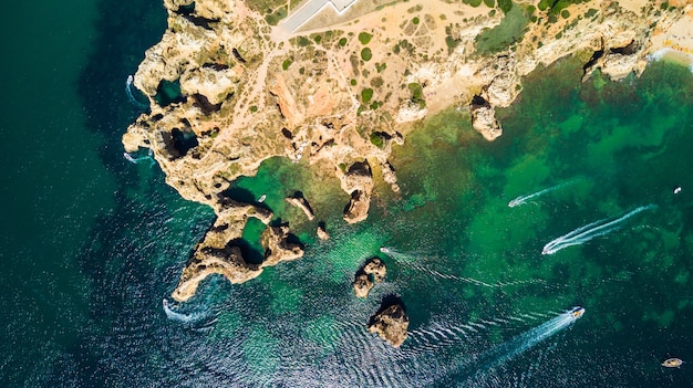 Aerial top view of Scenic Ponta da Piedade of Lagos, Portugal. Rugged seaside cliffs and aqua ocean waters in the Algarve region of Portugal