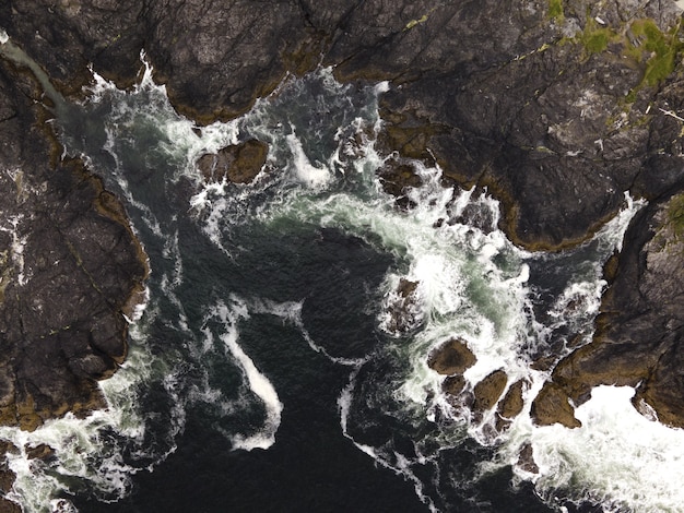 Free Photo aerial vertical shot of a sea with rocky mountains