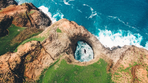 Aerial view of beautiful OpenCeiling Sea Cave on the Na Pali Coast of Kaua’i with greenery