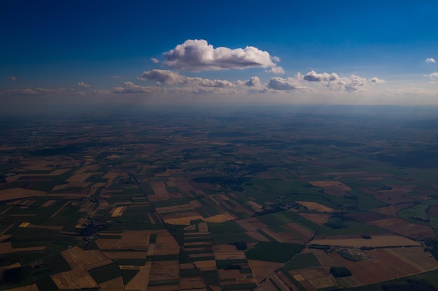 Free photo aerial view of the blue sky with white clouds floating above the fields