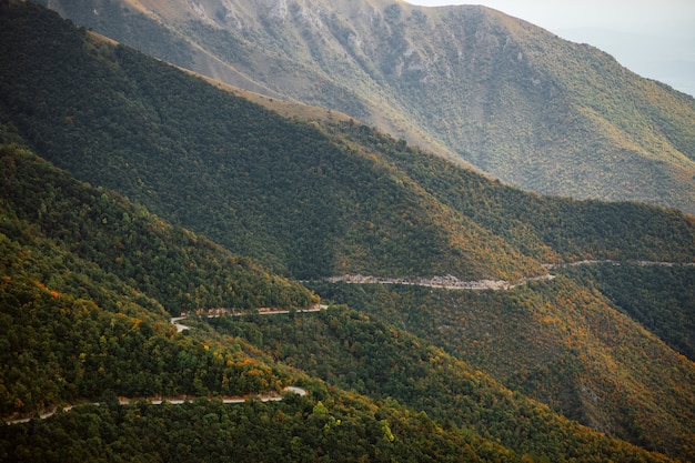 Aerial view of a countryside road passing through the trees and mountains