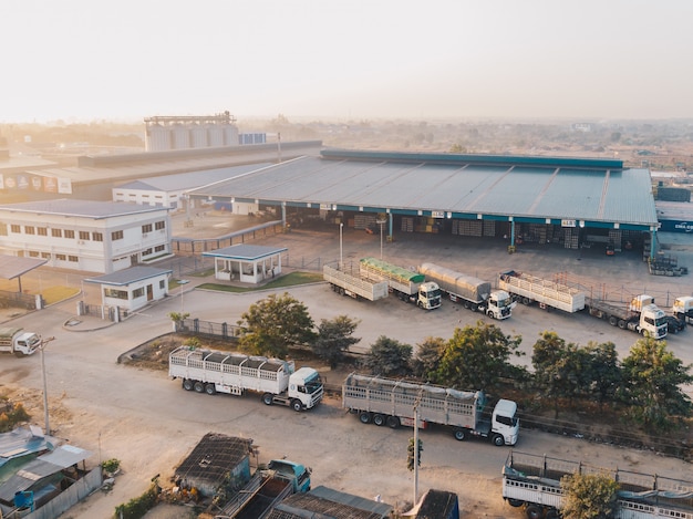 Aerial view of factory trucks parked near the warehouse at daytime