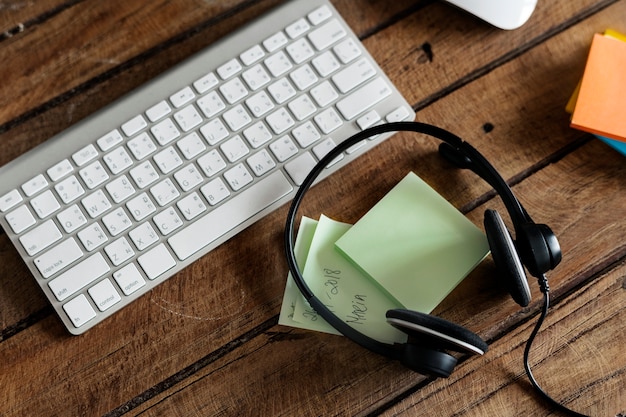 Aerial view of headphones and keyboard on wooden table