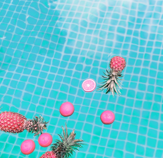 Free Photo aerial view of pineapple and oranges floating in a swimming pool